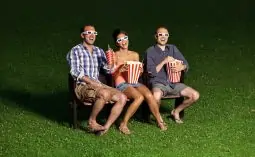 trois jeunes mange du pop corn en cinema plein air