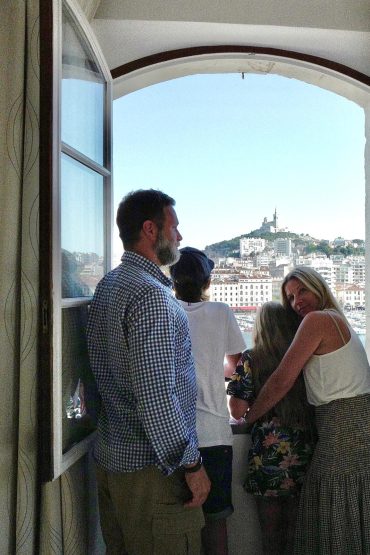 family - eco-friendly hotel Belle-Vue old port Marseille The Hotel Belle-Vue cultivates a subtle balance between authentic charm and modern comfort. Nestled on the Old Port of Marseille, it offers each guest a breathtaking view — of the quays, the boats, and the iconic silhouette of Notre-Dame de la Garde. The rooms, renovated in a "cozy" atmosphere, play with muted colors, woods, soft fabrics, and plush cushions: the desired effect is that of a warm nest, bathed in natural light thanks to large windows typical of Provençal architecture. Each room is distinguished by personalized decorative touches—a feature wall painted in a bold color, designer lamps, simple and elegant furniture, and textiles with graphic patterns. The overall effect creates an intimate and soothing atmosphere, ideal for relaxing after a day of exploring or wandering through the streets of Marseille. Attention to detail — premium bedding, mini-bar, air conditioning, Wi-Fi, etc. — guarantees modern comfort, while the style remains true to the Mediterranean spirit, without falling into ostentatious luxury. Thus, the Hotel Belle-Vue offers a simple yet refined setting, a successful blend of authenticity and well-being, ideal for those seeking a cozy and sincere stay in the historic heart of Marseille. Eco-friendly hotel Belle-Vue Old Port Marseille: Ambiance & Comfort — a cozy haven facing the Old Port